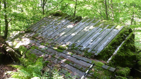 Durch die Sprengung wurde die Bunkerdecke angehoben und liegt nun nahezu umgedreht auf den Resten des Bauwerkes. Foto einer gesprengten Bunkerdecke