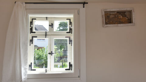 Ein historisches Fenster und ein Sichtfenster im Tagelöhnerhaus. Foto eines Fensters und Sichtfensters im Tagelöhnerhaus.