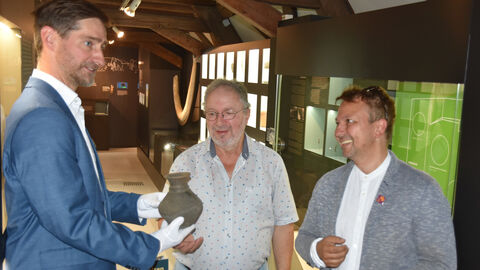 Foto. Peter Steffens M.A. (links) und Christoph Breitwieser M.A. (rechts) nehmen den Fund von Martin Reeb im Museum Bensheim entgegen.
