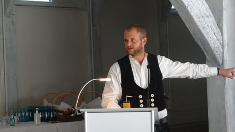 Tobias Engel von der Zimmerei Christ in Jossgrund stellte die liebevoll entwickelten Details der handwerklichen Umsetzung vor. Diese stehen für die besondere Atmosphäre der 1775 erbauten Scheune, in die nun eine Wellnessanlage integriert wird. Foto. Tobias Engel beim Denkmalgespräch.