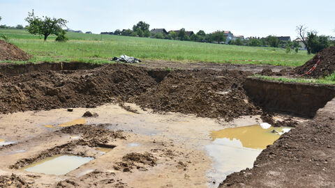 Zuletzt wurde es noch einmal hektisch, denn starke Regenfälle verwandelten die Ausgrabung in ein Schlammfeld. Foto. Grabungsfläche in Rockenberg nach starkem Regen.