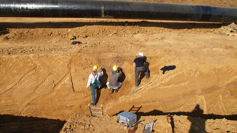 Das Bild zeigt Archäologen bei der Arbeit in einem Leitungsgraben.