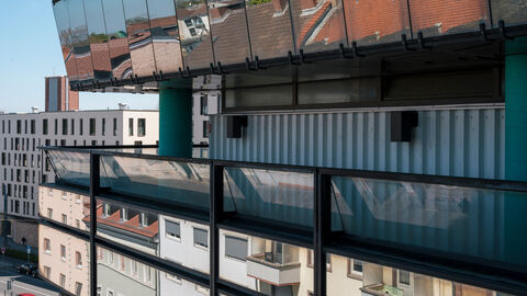 Man sieht einen Ausschnitt der Fassade, die ihre Umgebung spiegelt und einen Eindruck davon vermittelt, wie eindrucksvoll sich das 1977 erbaute Gothaer Haus in seinem Umfeld positioniert.