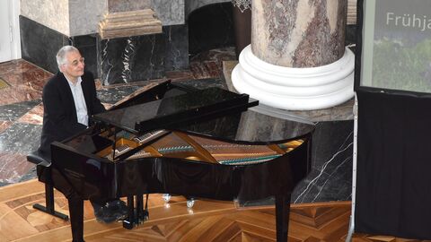 Ein Mann sitzt an einem Klavier.