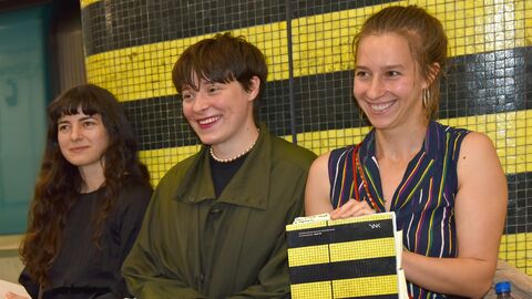 Drei Frauen (Annekathrin Warter, Helene Peters und Carina Kitzenmaier) sitzen nebeneinander und halten ein Buch in die Kamera.