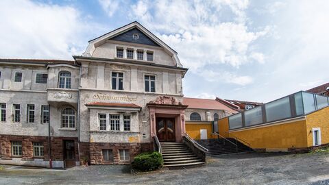 Der Haupteingang des Hallenbads im neobarocken Stil mit jüngerem Anbau. Das Gebäude von Außen