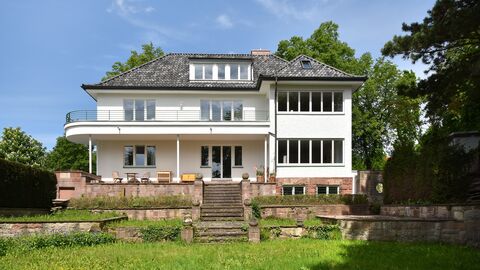 Zweigeschossiges weißes Haus mit grauem Ziegeldach