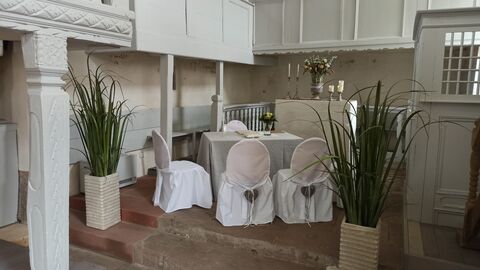 Standesamtliche Hochzeiten in der Alten Kirche Fünf weiß verhüllte Stühle stehen um einen Tisch