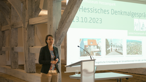 Dr. Henriette von Preuschen hielt einen Impulsvortrag. Frau von Preuschen steht an einem Redepult und spricht zum Publikum.