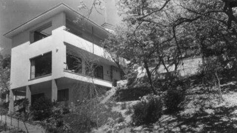 Schwarz-Weiß-Bild eines dreistöckigen Gebäudes mit großen Fensterflächen und Balkonen.