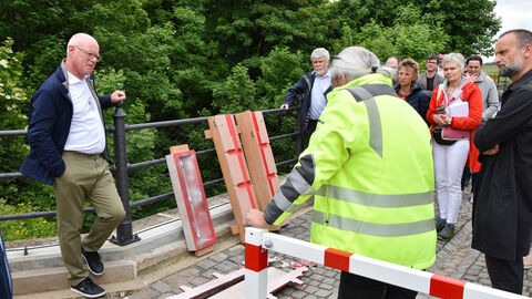 Mitglieder des Vereins Historische Brücke Hartmannshain e.V. erläutern die besondere Technik bei der Nachbildung der korriderten Pfosten, die nicht mehr instandgesetzt werden konnten. 