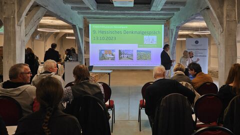 Veranstaltungsort des Denkmalgespräches war der Fruchtspeicher aus Trendelburg. Bild durch das Publikum auf die Leinwand.