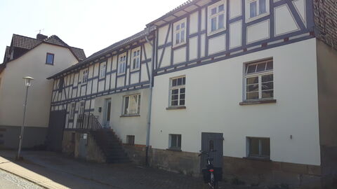 Straßenansicht von der Dorfstraße Zweigeschossiges traufständiges Fachwerkwohnhaus, mit einem einläufigen Treppenaufgang zur Haustür.
