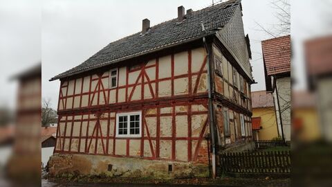 Traufseite eines zweigeschossigen Fachwerkbaus, mit rot gestrichener Balkenkonstruktion.