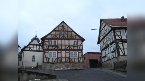 Blick auf die Giebelseite eines Fachwerkwohnhauses auf hohem Natursteinsockel. 