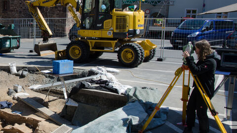 Auch die Vermessung, wie hier durch eine Freiwillige der Außenstelle Marburg, gehört zu den Aufgaben der Archäologie. Die genaue Lage der Funde und Befunde ermöglicht es, einen Gesamteindruck der Fundstelle zu gewinnen. Freiwillige bei der Vermessung.