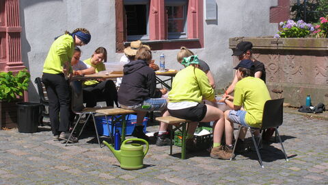 Funde wie Keramikscherben werden gewaschen, ehe sie restauriert oder eingelagert werden. Freiwillige waschen Funde.