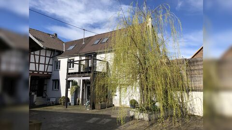 Innenhof mit zweigeschossigem Wohnhaus und vorgestellten Balkon im Hintergrund