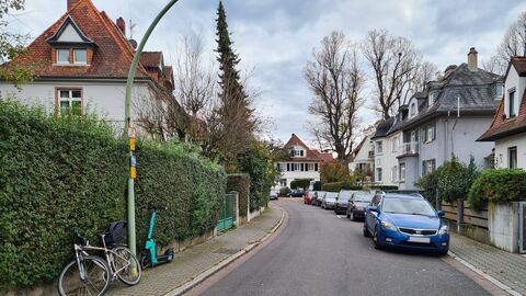 Blick durch eine Straße der Villenkolonie. Die Straße ist leicht gebogen und die Häuser sind variantenreich, aber im Stil der Villenkolonie ausgestaltet.