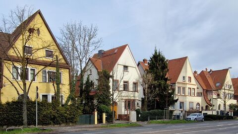 Man sieht vier nebeneinander stehende Häuser. Typisch für die Häuser in der Villenkolonie haben sie alle hohe Giebeldächer und verschieden ausgeformte Erker und Gauben.