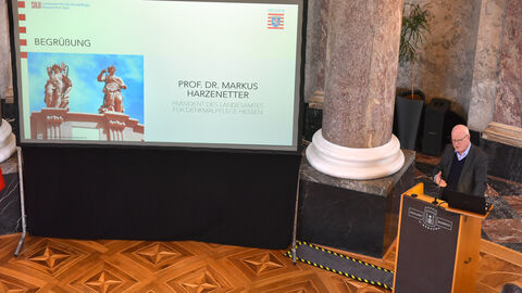 Man sieht Prof. Dr. Markus Harzenetter, den Präsidenten des Landesamtes für Denkmalpflege Hessen, bei der Begrüßung der rund 200 geladenen Gäste n der Rotunde des Biebricher Schlosses.  