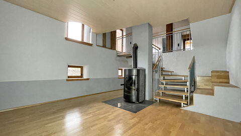 Großer heller Wohnbereich mit Parkettboden und einem Kamin. 