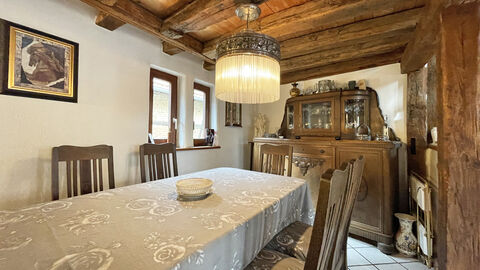 Blick auf einen Essbereich in einem Fachwerkwohnhaus mit offener Holzbalkendecke. 