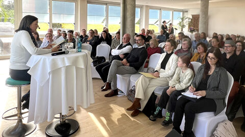 Man sieht Susanne Kronenberg bei ihrer Lesung aus dem Buch "Weinrache" in dem hoch über Wiesbaden gelegenen Drei-Lilien-Saal der Wagner Gastronomie, Auf dem Neroberg 2 in 65193 Wiesbaden.