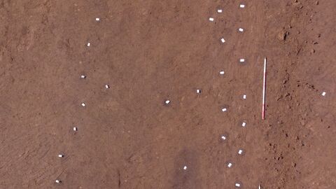 Teilweise freigelegtes Nebengebäude mit markierten Pfostenstellungen.