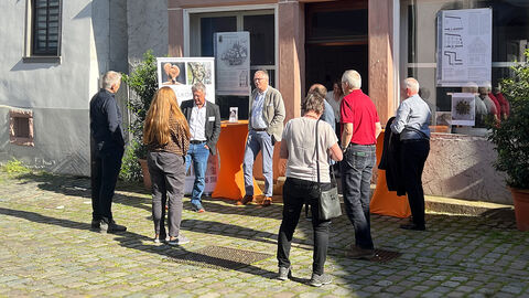 Die Besucher und Besucherinnen der Veranstaltungen kommen vor der Synagoge zum Austausch zusammen.