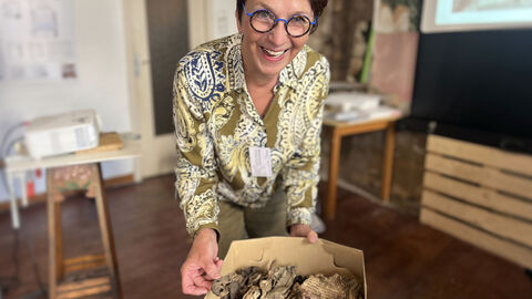 Monika Slomski hält eine Kiste mit den Überresten der gefundenen hebräischen Seiten in die Kamera
