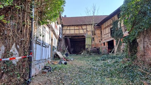 Haupthaus, Scheune und Stall, allesamt Fachwerkgebäude. Die Gefache in Scheune und Stall sind beige.