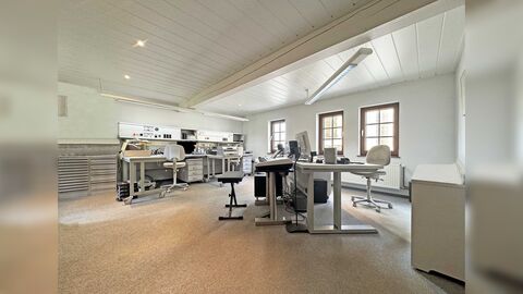 Zimmer mit Schreibtischen und Bürostühlen