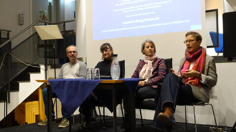 Sebastian Gulden, Hanna Rentschler von der Stadt Friedberg, Hanna Dornieden und Verena Jakobi vom Landesamt für Denkmalpflege Hessen sitzen vor den Gästen und beantworten Fragen.