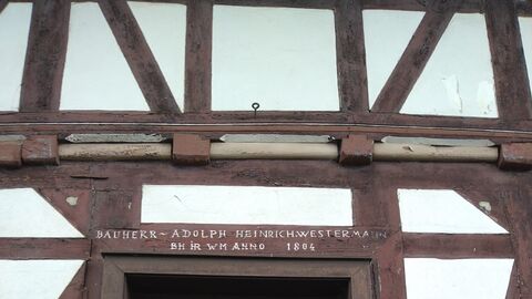 Bauherr und Baujahr sind in einer Inschrift über der Tür festgehalten Inschrift in einem Balken: Bauherr Adolph Heinrich Westermann BH IR WM Anno 1804