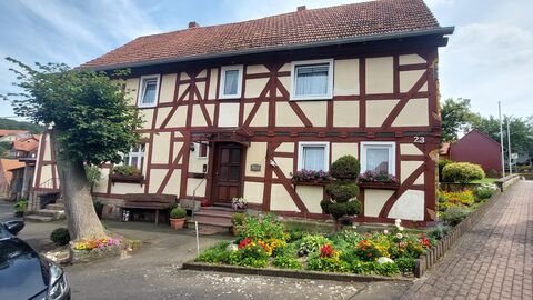 Eingangsseite eines Fachwerkhauses mit rötlichem Fachwerk und beigen Gefachen 