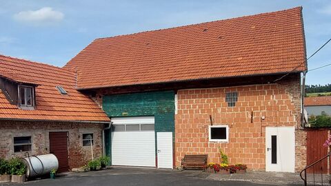 Rot eingedeckte Gebäude mit sichbarem Mauerwerk