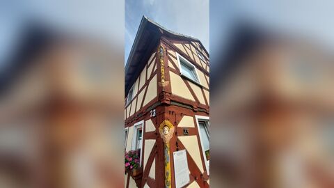 Bunt angemalte Figuren, die in das Fachwerk hineingeschnitzt wurden