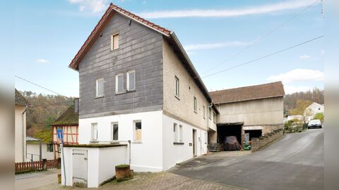 Blick von der Burgstraße auf das Haus. Im Hintergrund quer ist die Scheune zu erkennen. Giebelständiger Bau mit zwei Vollgeschossen und einem Dachgeschoss. Das Haus ist weiß verputzt, die Giebelseite oberhalb des Erdgeschosses ist verkleidet.