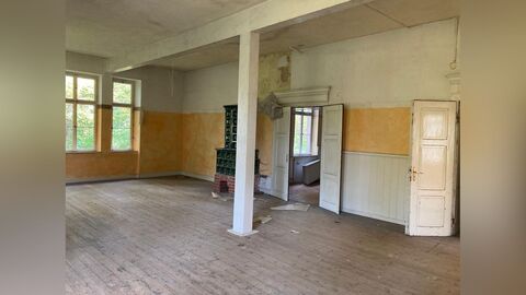 Rückwärtige Fassade. Weiß verputzte Fassade eines großen Gebäudes mit zwei Vollgeschossen und einem rot eingedeckten Mandarddach. die Fassade ist symmetrisch aufgebaut 