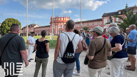 Die erste Station vor dem Biebricher Schloss. Wenzel Bratner führt in die Geschichte des Schlosses und die Bedeutung des Schlossparks ein. Wenzel Bratner bei der Führung vor dem Biebricher Schloss.