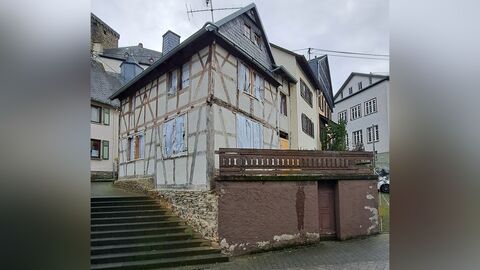 Fachwerkhaus auf Natursteinsockel. Im Sockelbereich befindet sich die Eingangstür zum Keller