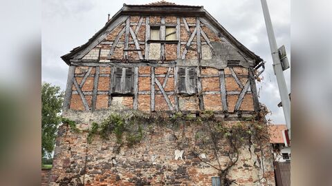 Blick von Westen auf das Gebäude Querseite eines zweigeschossigen Baus mit einem massiv gemauerten Erdgeschoss und einem Fachwerkobergeschoss mit beidseitigem Halbwalm.