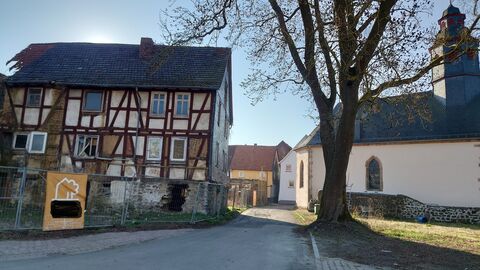 Das Haus steht in unmittelbarer Nähe zur Kirche Links im Bild das Fachwerkhaus, rechts die Kirche