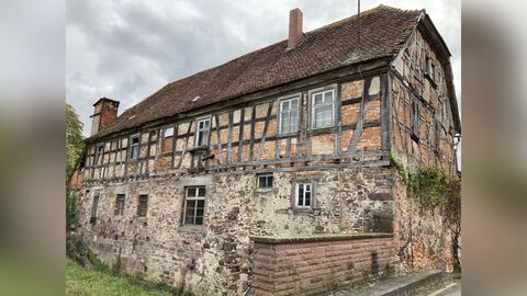 Blick von Nordosten auf das Gebäude Längsseite eines zweigeschossigen Baus mit einem massiv gemauerten Erdgeschoss und einem Fachwerkobergeschoss mit beidseitigem Halbwalm.
