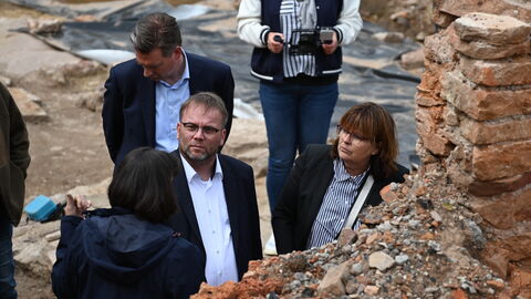 Bezirksarchäologin Dr. Eveline Saal zeigt Oberbürgermeister Schoeller, Staatsminister Gremmels und Landtagsabgeordneter Esther Kalveram die erhaltenen Mauerzüge.
