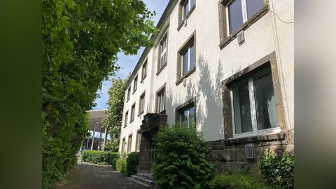 Weiß verputzes Haus mit Fenstergewänden und Sockel aus Tuffstein.