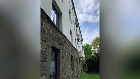 Weiß verputzes Haus mit Fenstergewänden und Sockel aus Tuffstein.