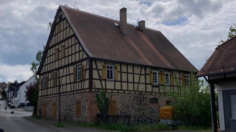 Nordansicht des Gebäudes Großvolumiges Fachwerkhaus mit Erdgeschoss aus Bruchstein und einem Satteldach mit roter Biberschwanzeindeckung.