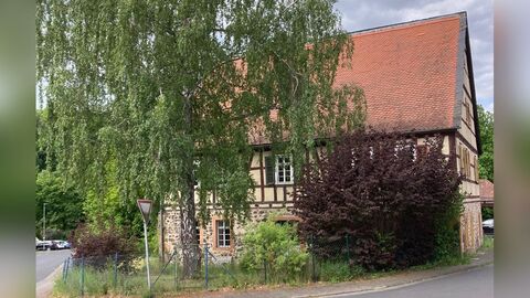 Südansicht des Gebäudes Großvolumiges Fachwerkhaus mit Erdgeschoss aus Bruchstein und einem Satteldach mit roter Biberschwanzeindeckung.